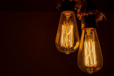 Illuminated light bulb against black background