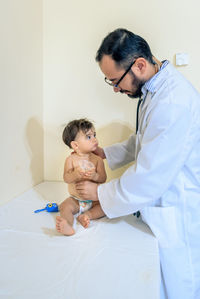 Doctor observing a one-year-old baby