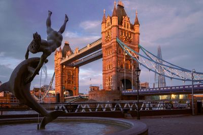 Statue of bridge against cloudy sky