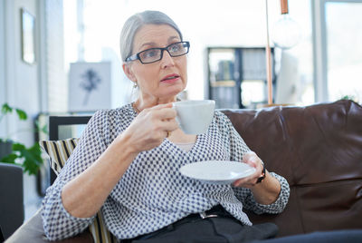 Portrait of young man drinking coffee at home