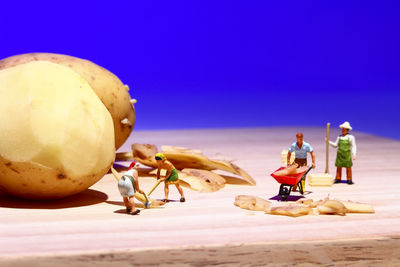 Close-up of figurine on table against blue sky