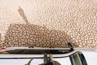 Low section of man standing on off-road vehicle at barren landscape