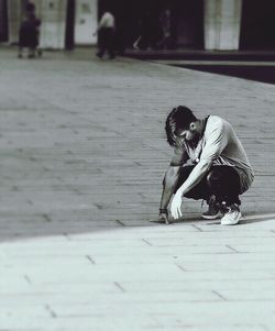 Full length of teenage girl sitting in city