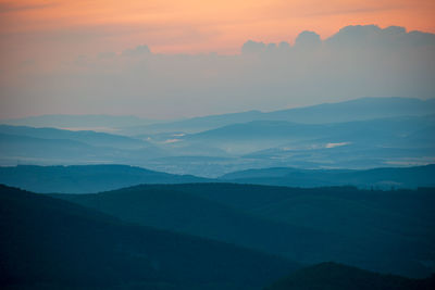 Scenic view of silhouette mountains against sky during sunset