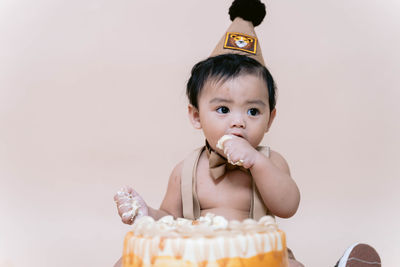 Portrait of a cute little  boy sitting and eating his birthday cake