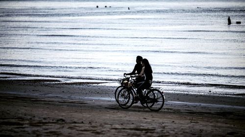 Man riding bicycle on beach