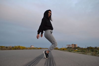 Full length of woman on road against sky