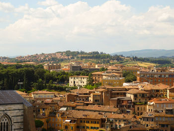 Aerial view of city against cloudy sky