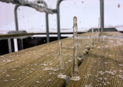 Close-up of wet railing against blurred background