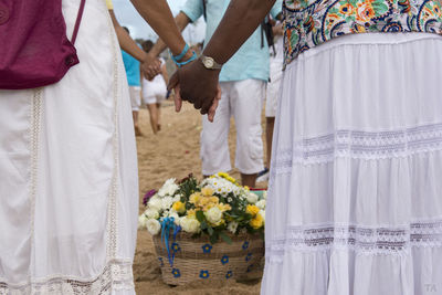 Group of people holding hands in a circle on the beach