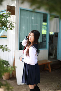 Girl smiling woman standing against built structure