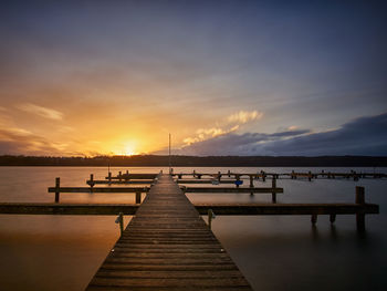Pier over sea against sky during sunset