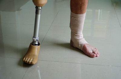 Low section of person standing on tiled floor