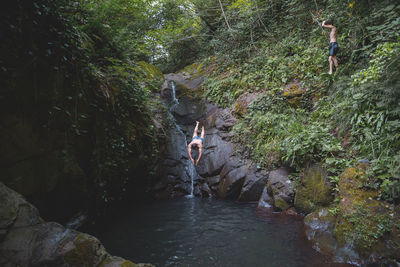 Man diving into pond at forest