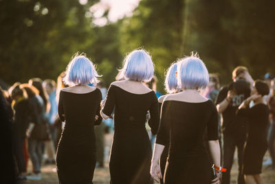 Rear view of women with people in background