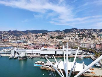 Aerial view of harbor by buildings in city against sky