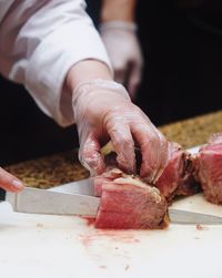 Cropped image of man cutting pork