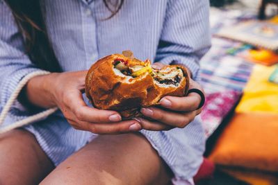 Midsection of woman holding burger