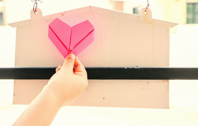 Close-up of hand holding pink umbrella