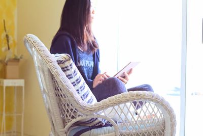 Young woman sitting on sofa at home