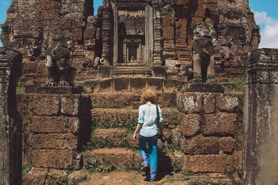 Rear view of woman standing at old ruined temple