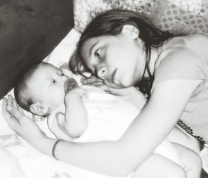 High angle view of sibling lying on bed at home