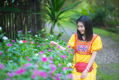 Smiling woman looking at flowers