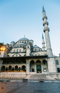 Low angle view of historic mosque in city against sky