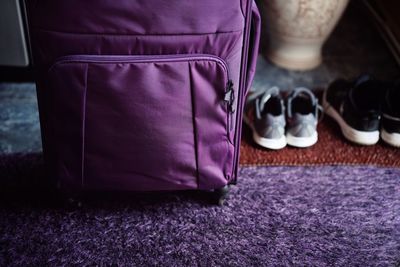 Close-up of suitcase and shoes on rug