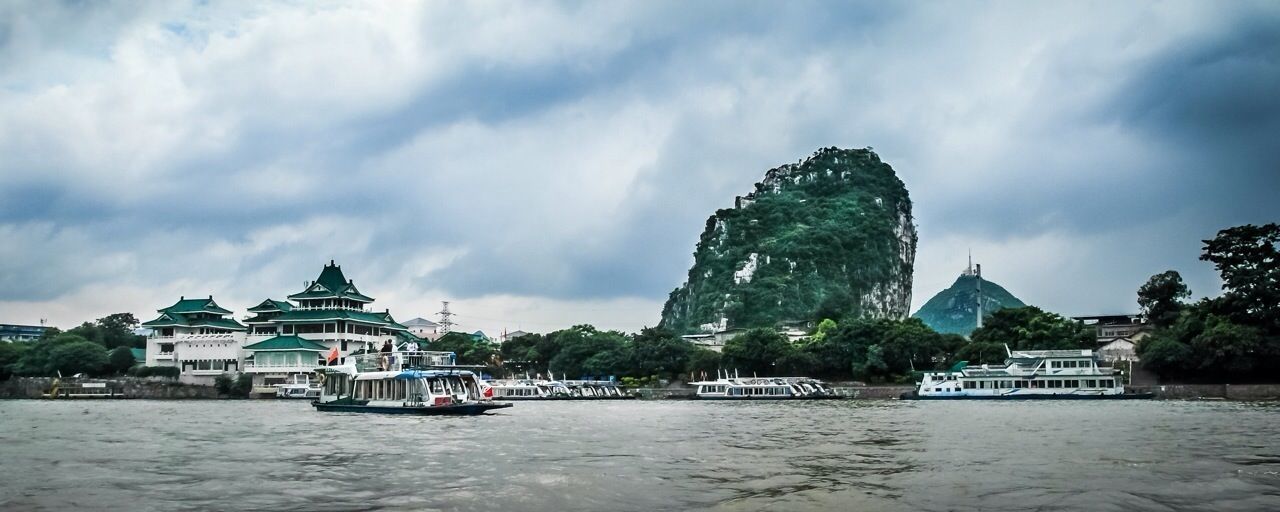 water, waterfront, architecture, building exterior, built structure, sky, nautical vessel, cloud - sky, transportation, tree, mode of transport, boat, river, cloudy, cloud, travel, sea, travel destinations, tourism, famous place