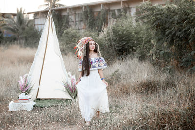 Boho bohemian girl styled wearing indian maxi dress and jewellery in autumn field