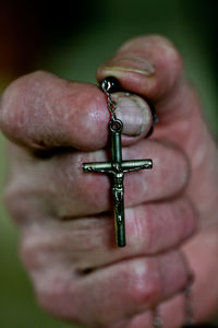 Close-up of human hand holding cross