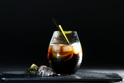 Close-up of drink on glass against black background