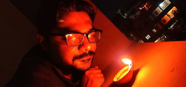 Portrait of man smoking cigarette against fire in the dark