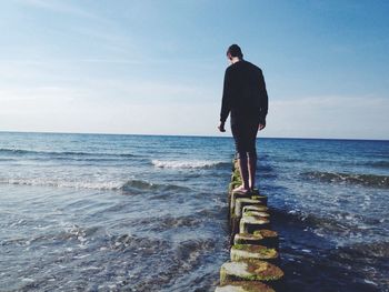 Rear view of woman standing on beach