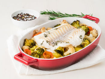 High angle view of baked cod fish served in bowl on table