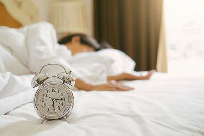Low section of man sleeping on bed at home