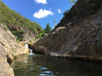 Scenic view of waterfall against sky