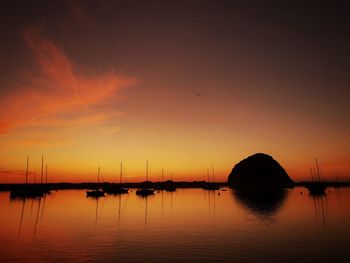 Silhouette sailboats in sea against sky during sunset