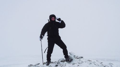 Full length of man standing on snow covered field