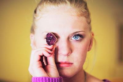 Close-up portrait of young woman holding crystal