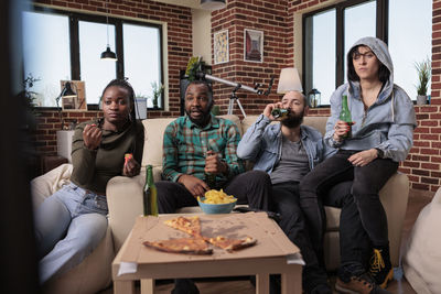 Portrait of smiling friends sitting at home