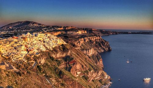 Houses on cliff by sea at dusk