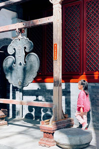 Women standing on metal outside building