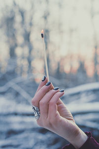 Close up female hand holding burning match concept photo