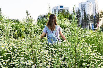 Woman standing by flowering plants