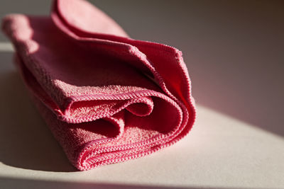 A pink nonwoven cloth lying in the windowsill as the sun goes down