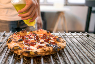 Midsection of woman holding pizza on table