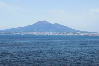 Scenic view of sea and mountains against sky