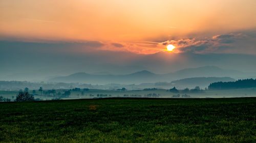 Scenic view of field against sky during sunset